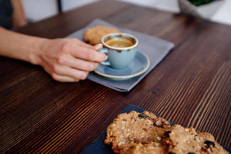 Hand holds a cup of coffee. Espresso and cookies.の写真素材