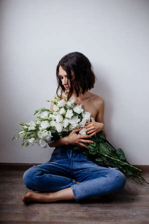 Beautiful girl with a bouquet flowers.の写真素材