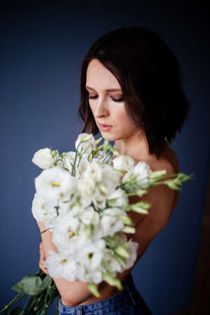 Beautiful girl with a bouquet flowers.の写真素材