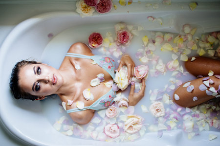 Beautiful girl in the bathroom with many flowers.