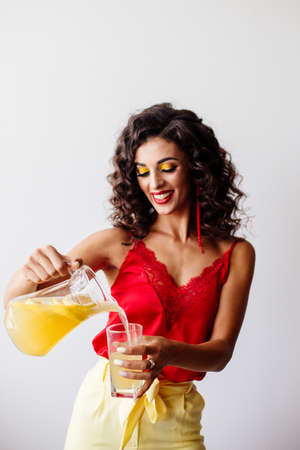 Beautiful fashion brunette with curly hair with lemonade.の写真素材