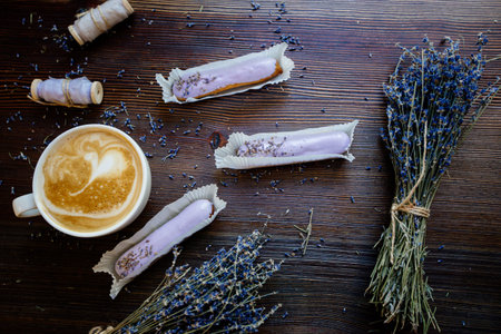 Cappuccino, eclairs and flowers.の写真素材