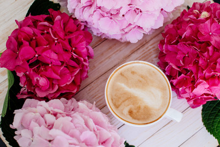 Cup of cappuccino and flowers.