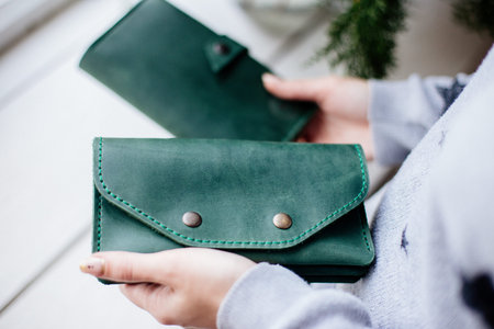 Girl holding a green money wallet.