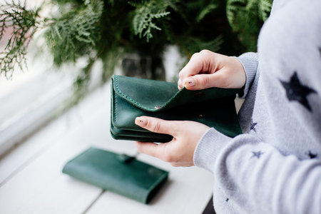 Girl holding a green money wallet.