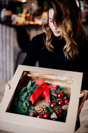 Red christmas wreath on table.