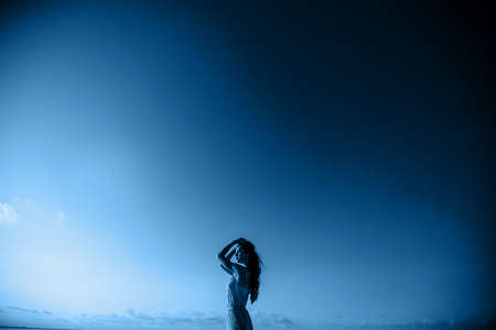 Beautiful woman on background blue sky.の写真素材