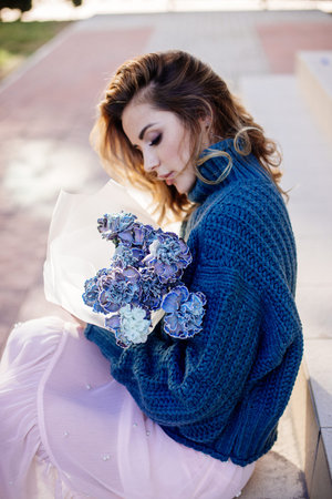 Image of cute woman with blue bouquet.の写真素材
