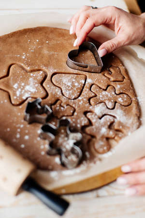 Making traditional Christmas cookies. Spices on the table - anise, cardamom, cinnamon, cloves. Raw dough and cutters for holiday cookies on the table. Prepare the gingerbreadの写真素材