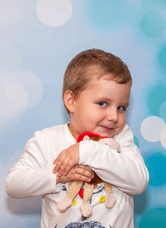 Child Emotions. Funny boy. A boy with blue eyes. Portrait. With a toy in his handsの写真素材