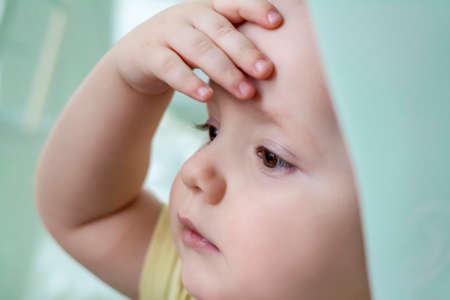 The baby looks out the window, misses walking on the street.の写真素材