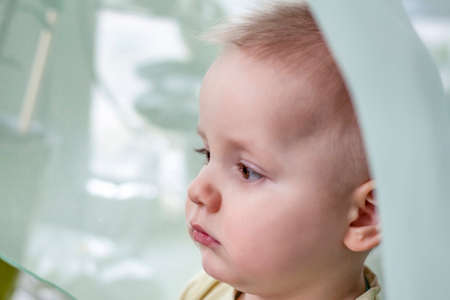 The baby looks out the window, misses walking on the street.の写真素材