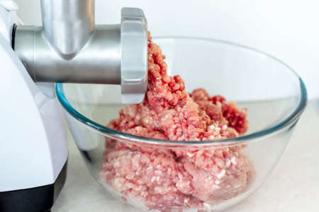 Meat in a meat grinder. Food preparation. Meat for cutlets. Production. Minced meat.の写真素材