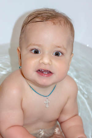 The child is bathing in the bath. Games in the water. Bathing a child. Toys in the bath.の写真素材