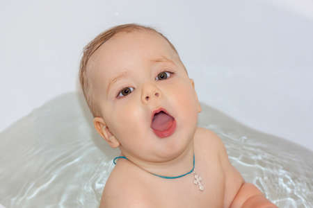 The child is bathing in the bath. Games in the water. Bathing a child. Toys in the bath.の写真素材