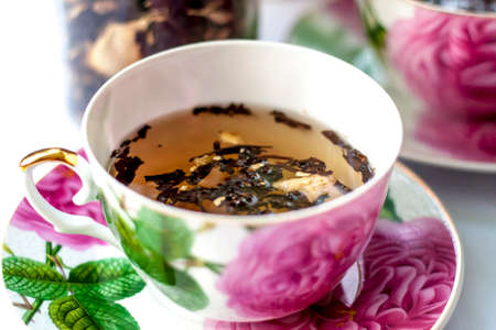 Cup of tea. Large tea leaves in a Cup. A can of tea. Large-leaf tea with fruit.の写真素材