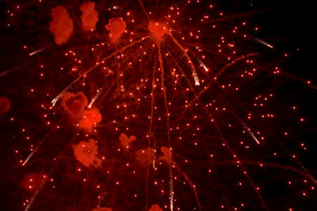 Salute. Bright, red splashes of fireworks in the dark sky. Night fireworks.の写真素材