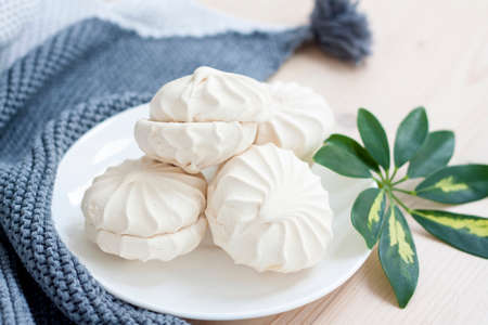 Marshmallows. Vanilla sweet homemade marshmallows. Light composition with green natural leaf and plaid. Violet flower. Sweet delicious dessert.の写真素材
