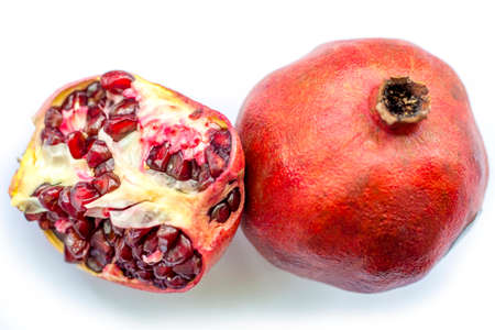 Ripe and juicy pomegranate cut on a white backgroundの写真素材