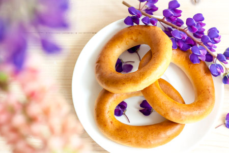 Sweet bagels and tender lupine flowers. Light composition with bright and purple flowers. A tender...