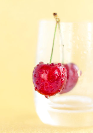 Sweet cherries. Red cherries hang on a transparent glass. Ripe berry. Bright summer background for...