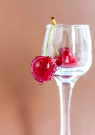 Sweet cherries. Red cherries hang on a transparent glass. Ripe berry. Bright summer background for presentations and graphic works.の写真素材