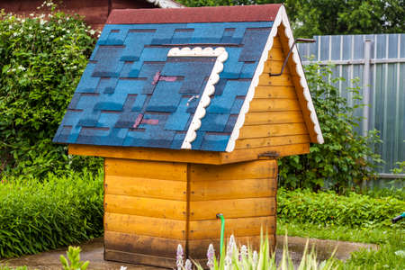 A beautiful village well with a blue roof. A well with drinking water stands in the village courtyard.の写真素材