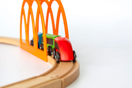 Children's railway made of wood on a white background. Wooden colored trailers. Toys for children...