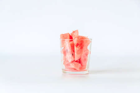 Red ripe watermelon, cut into pieces on a white background in the scan. Watermelon slices in a glass.の写真素材