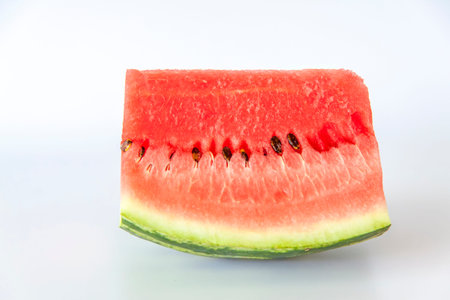Red ripe watermelon sliced on a white background. Watermelon slices lie on the surface. White...
