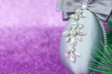 Gray Christmas ball in rhinestones for Christmas tree decoration. Christmas toy. Christmas toy for decorating a Christmas tree on a lilac background. Shining crystals on a gray ball. Christmas and new year.の写真素材