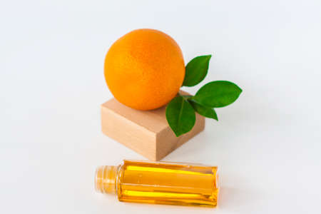 Orange oil for the body. Orange on a white background. Organic SPA cosmetics with herbal ingredients. Cosmetology.の写真素材