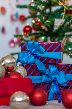 Holiday gifts with blue bows under the tree. Christmas and New year. The concept of an advertising banner.の写真素材