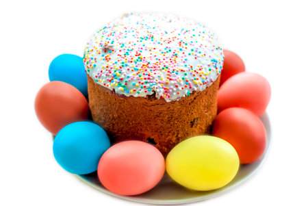 Cake and colored eggs on a platter. Easter lunch. The feast of Holy Easter. Painted eggs. White...