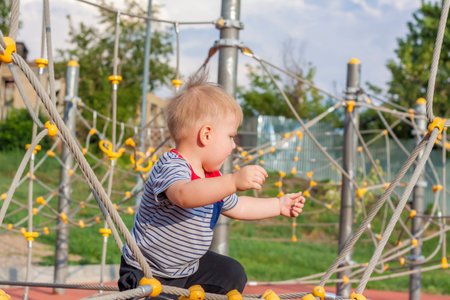 A little boy enthusiastically plays on the playground. Success, creative ideas and sports concepts. Children's playground. Games.の写真素材