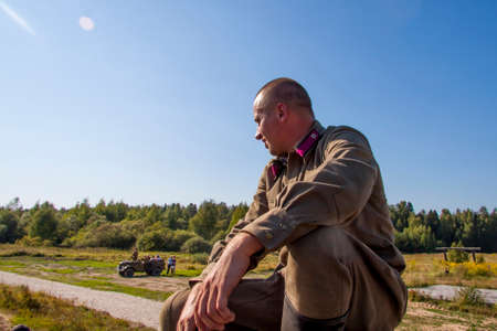 Moscow, Russia, 2018-08-25, exhibition of military equipment, display of military vehicles in action. A military man in uniform sits on a hill. Militaryのeditorial素材
