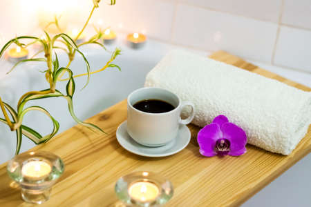 Spa-beauty salon, wellness center. Aromatherapy spa treatment for the female body in the bathroom with a cup of coffee, candles, oils and salt. Lifestyle and cosmetic conceptの写真素材