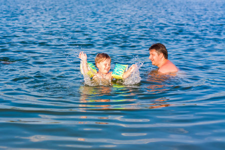 A family, a father and his sons are swimming in the river on a very hot summer day. Swim in...