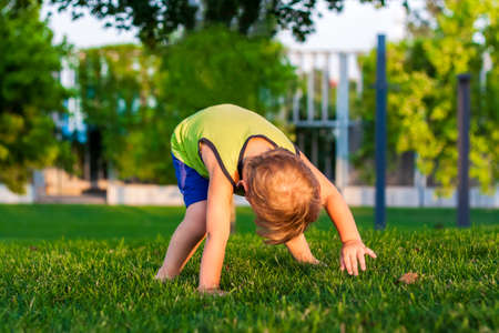 The child spends time in the park, he is very happy. Have fun and enjoy a summer day. Walking and recreation. Portrait of a happy childの写真素材