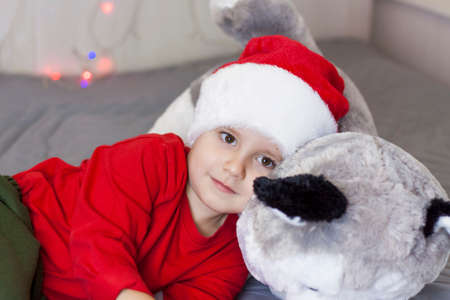 Portrait of a cute boy in a Santa Claus hat. Funny smiling child. Christmas concert.の写真素材
