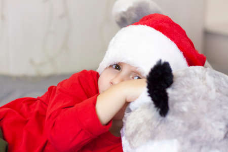 Portrait of a cute boy in a Santa Claus hat. Funny smiling child. Gifts, toys, joy, celebration. Christmas concert.の写真素材