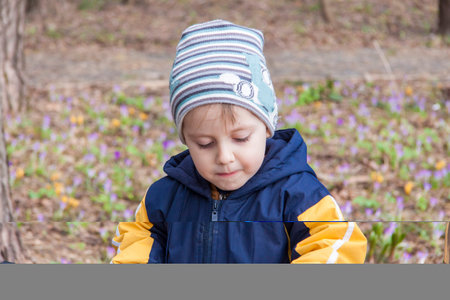 portrait of a cute boy in the park in spring. A boy in a hat on the street. Walk, play and have fun....