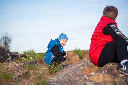A child sits on top of a cliff and watches what is happening below. panoramic view from the top of a rocky mountain. Russia, Rostov region, skelevataya skala, the 7th wonder of the Don world. Landscapeの写真素材