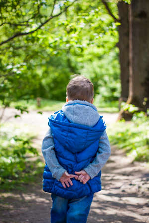 Portrait of a boy in the forest in spring. Take a walk in the green park in the fresh air. The magical light from the sun's rays is left behind. Space for copying. selective focus. Springの写真素材