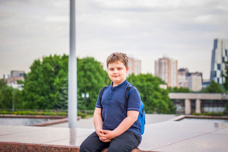 Portrait of a child, a boy against the backdrop of urban landscapes of skyscrapers and high-rise buildings in the open air. children, travel. Lifestyle in the city. Center, streets. Summer, a walk.の写真素材