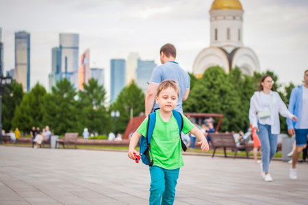 Portrait of a child, a boy against the backdrop of urban landscapes of skyscrapers and high-rise buildings in the open air. children, travel. Lifestyle in the city. Center, streets. Summer, a walk.の写真素材