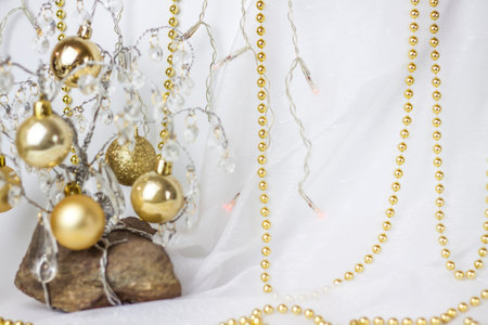Christmas background with a Christmas tree on which small golden balls hang. Selective focus, a picture for the background. the concept of Christmas and New Year.の写真素材