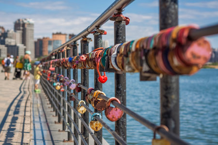 A heart-shaped door lock, a symbol of love and fidelity with a lake in the background, hangs on the fence of the bridge. The heart-shaped castle symbolizes loyalty and love.の写真素材