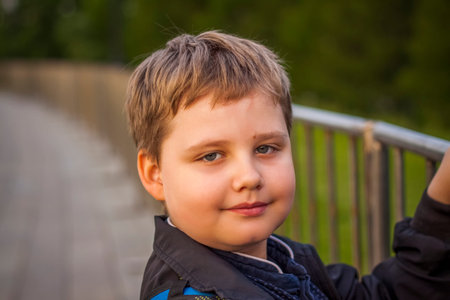 Portrait of a child, a boy against the backdrop of urban landscapes of skyscrapers and high-rise buildings in the open air. children, travel. Lifestyle in the city. Center, streets. Summer, a walk.の写真素材