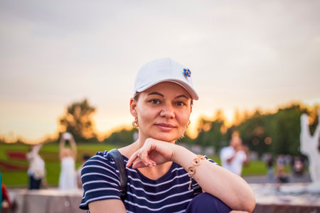 Portrait of a girl in a cap on the background of an open-air urban landscape. Travel. Lifestyle in the city. Center, streets. Summer, a walk.の写真素材